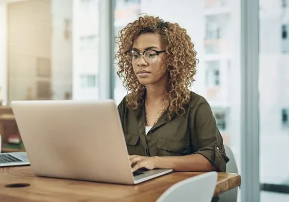 A woman working intently on her laptop