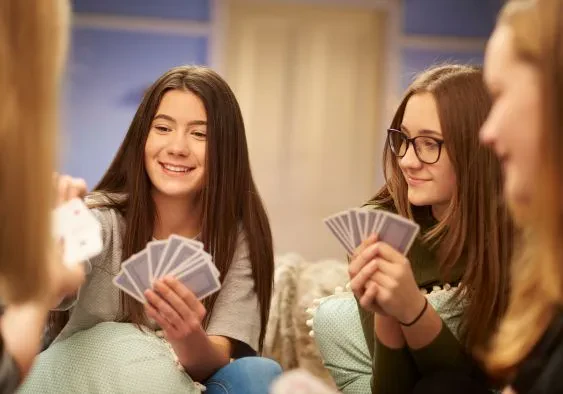 A group of teenage girls playing cards happily