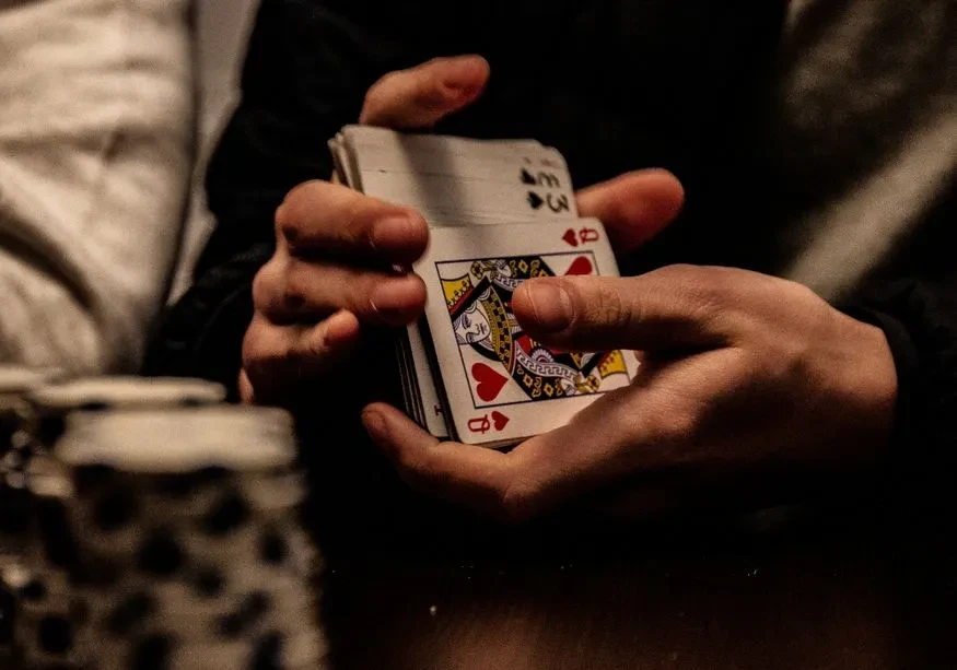 A deck of cards being shuffled in preparation for a game of hearts of spades